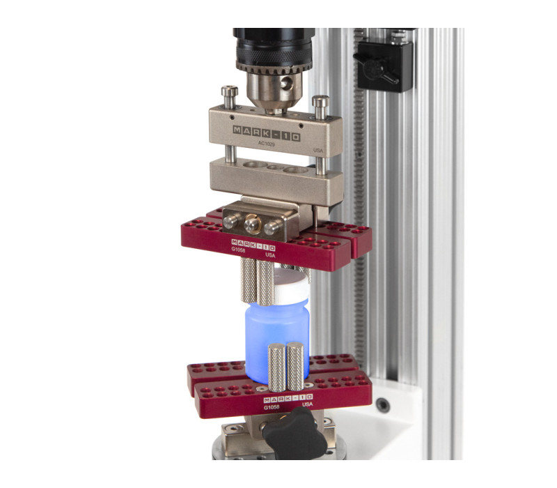 G1058 montado en la placa de carga de torsión mediante el adaptador G1055 y en el R50 encima de la botella de prueba con el compensador axial AC1029.
